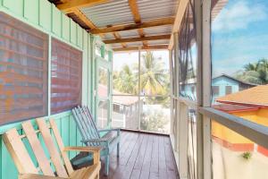 eine Veranda mit Schaukelstuhl und Meerblick in der Unterkunft Carol's Cabanas in Placencia Village