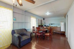 ein Wohnzimmer mit einem Sofa, einem Tisch und Stühlen in der Unterkunft Carol's Cabanas in Placencia Village