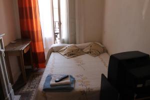 マドリードにあるオスタル グラシエラのベッド1台とテレビが備わる小さな客室です。