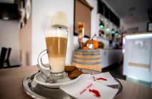 een kop koffie en koekjes op een bord op een tafel bij CVSE Clubház és Panzió in Cegléd