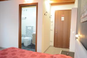 ein Schlafzimmer mit einem Bett und ein Badezimmer mit einem WC in der Unterkunft B&B Casa Taty in Dolo