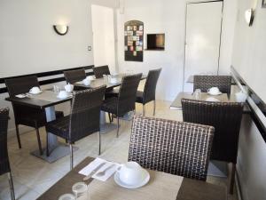 - un restaurant avec des tables et des chaises dans une salle dans l'établissement Hotel De La Poste, à Ganges