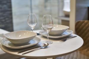 a table with two wine glasses and plates on it at K51 Apartman | Budapest in Budapest