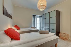 a bedroom with two beds and a large window at Cooleq Apartments Ogarna by TriApart in Gdańsk