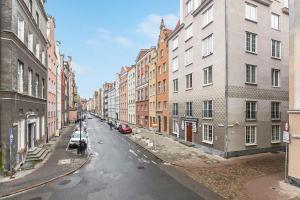 an empty street in a city with buildings at Cooleq Apartments Ogarna by TriApart in Gdańsk