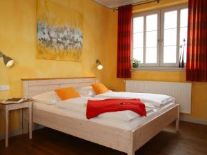 a bedroom with a large bed with a red blanket on it at Weinhof am Nussbaum in Willanzheim