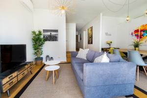 ein Wohnzimmer mit einem blauen Sofa und einem TV in der Unterkunft ALTIDO Bairro Alto 2-BR Apartment with Large Terrace in Lissabon