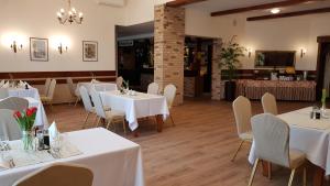 a dining room with white tables and chairs at Motel Pintal in Gorzów Wielkopolski