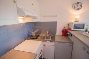 a small kitchen with a sink and a microwave at Les Genêts in Mimizan-Plage