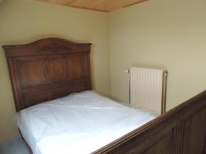 a bed with a wooden headboard in a room at Vakantiehuis " Te Lande " in Torhout