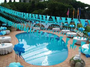 
a swimming pool filled with lots of blue umbrellas at Gran Sol Hotel in San Pol de Mar
