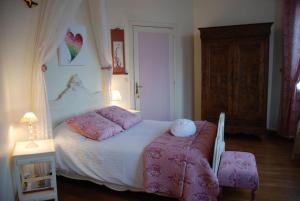una camera con un letto bianco e lenzuola rosa di Domaine de l'Oie Rouge a Les Rosiers