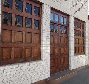 een paar houten garagedeuren op een gebouw bij Liliom in Szeged