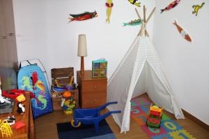 una camera con tenda per giocare e giocattoli appesi alla parete di Apartamento em frente ao Mar a Costa Nova