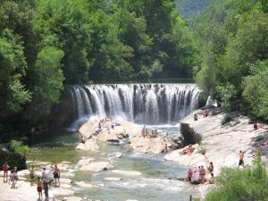 a group of people swimming in a waterfall at Hotel De La Poste in Ganges