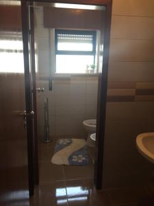 a bathroom with a toilet and a window and a sink at Holidays Vista Mar Nazare in Nazaré +27 photos