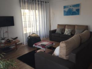 a living room with a couch and a table at Holidays Vista Mar Nazare in Nazaré