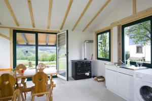 een keuken met een tafel, een wastafel en een wasmachine bij Bergoase Hütte und Hostel Sauna Kamin Lagerfeuer in Mittelndorf