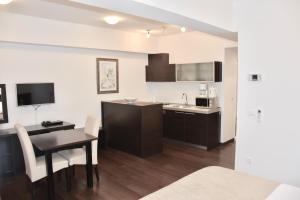 a kitchen with a table, chairs and a refrigerator at Celenga Apartments with free offsite parking in Dubrovnik