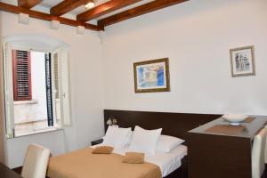 a bedroom with a bed and a desk and a window at Celenga Apartments with free offsite parking in Dubrovnik