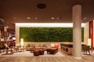 a living room with a couch and a green wall at IntercityHotel Frankfurt Hauptbahnhof Süd in Frankfurt