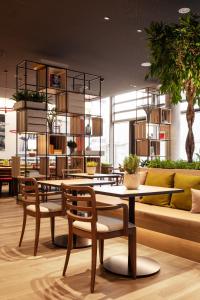 a restaurant with tables and chairs and a couch at IntercityHotel Frankfurt Hauptbahnhof Süd in Frankfurt