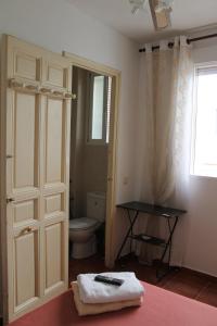 a bathroom with a toilet and a window and a door at Hostal Graciela in Madrid