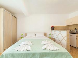 a bedroom with a large bed with two white towels at Hana Accommodation in Sveti Stefan
