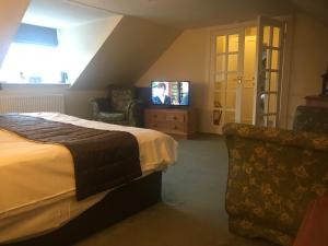 a hotel room with a bed and a television at Creebridge House Hotel in Newton Stewart
