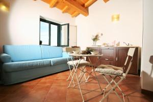a living room with a blue couch and a table at Agriturismo Le Case Del Merlo in Milo
