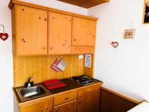 a kitchen with wooden cabinets and a sink at Casa Focobon - presso Sussy residence in Falcade +29 photos