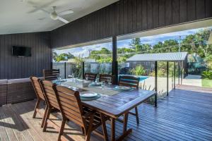 - une salle à manger avec une table et des chaises en bois dans l'établissement Byron Bay Accom Byron Beausoleil - Belongil Beach, à Byron Bay