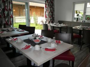 ein Esszimmer mit Tischen und Stühlen mit Geschirr in der Unterkunft Gästehaus Stahuber in Feldkirchen-Westerham