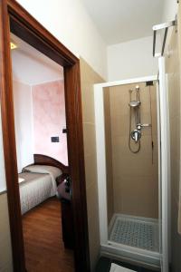 Cette chambre comprend un lit et une salle de bains pourvue d'une douche. dans l'établissement Drake, à Maranello