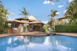 a large swimming pool in front of a house at Byron Bay Accom Calinda Sol 7 in Byron Bay