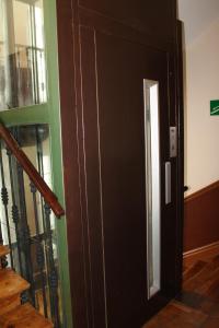 Una puerta negra en una habitación con escalera en Hostal Graciela, en Madrid