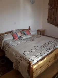 a bedroom with a large bed with pillows on it at Casa cu Muscate in Cîmpeni
