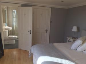 a bedroom with a bed and a bathroom with a sink at Strandview Beach Apartment in Ballycastle