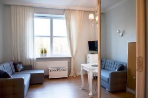 uma sala de estar com um sofá, uma mesa e uma janela em Gagarina 33 - studio by Homeprime em Varsóvia