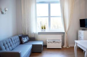 a living room with a blue couch and a window at Gagarina 33 - studio by Homeprime in Warsaw +3 photos