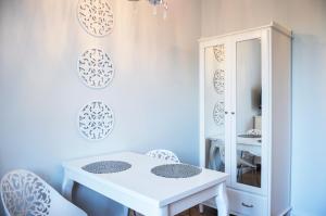a white table and chairs in a room with a mirror at Gagarina 33 - studio by Homeprime in Warsaw