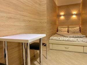 Habitación pequeña con cama y mesa en Невелика Smart квартира в центрі для пари en Leópolis
