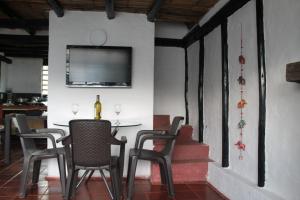 a dining room with a table and chairs and a television at Chalet Guatavita - Tominé. La Casa Amarilla in Guatavita