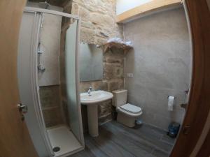 a bathroom with a sink and a toilet and a shower at Albergue A Salazon in Villanueva de Arosa
