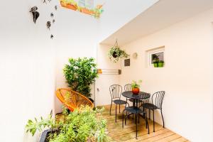 a patio with a table and chairs and plants at São Miguel Apartments in Porto