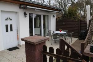 a patio with a white door and a table and chairs at Ferienwohnung am Schwielochsee in Schwielochsee