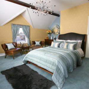 a bedroom with a large bed and a chandelier at The Mainstay Luxury Boutique Rooms with Private Parking in Whitby
