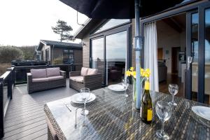 a patio with a table with wine glasses on it at Horizon Lodge in Sizewell