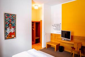 a room with a bed and a television on a table at Hotel Gut Schwaige in Ebenhausen