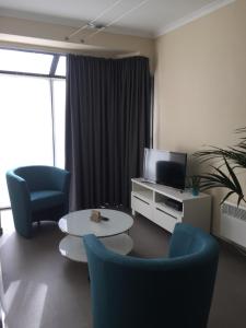 奧斯坦德的住宿－皇家公園公寓，客厅配有两把椅子和电视